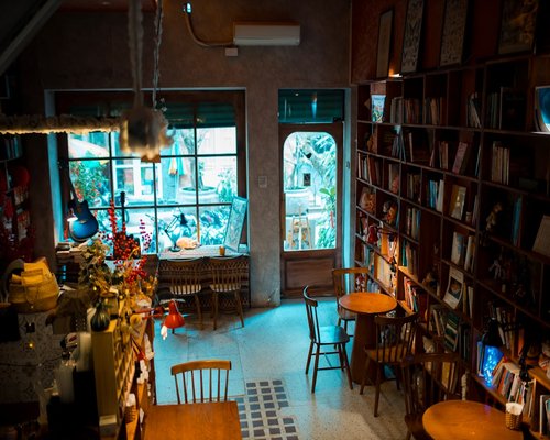 A warmly lit coffee shop interior with books