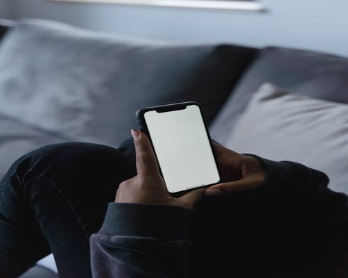 Hands holding a smartphone indoors